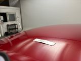 a red car with a sticker on it in a garage