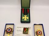two medals and a medal in a box on a white surface
