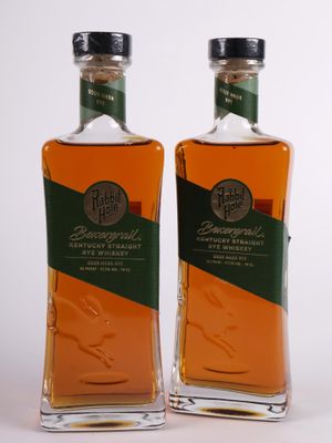 deux bouteilles de bourbon posées l'une à côté de l'autre sur une surface blanche