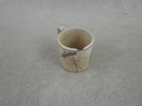 une petite tasse posée par terre