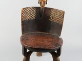 une image représentant une chaise en bois dont le dossier est orné d'un crâne