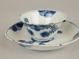 a blue and white cup and saucer sitting on a table