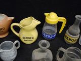 many different types of vases and pitchers on the table