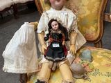a doll sitting on a chair in a room