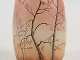 un vase orné d'un arbre, posé sur une table