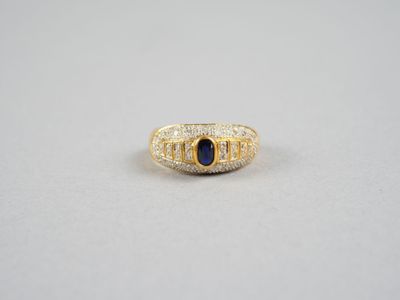une bague en or jaune sertie d'une pierre bleue entourée de diamants