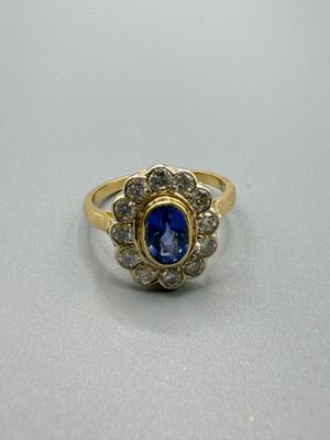 gros plan d'une bague en or avec une pierre bleue