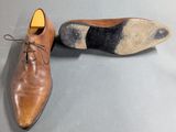 pair of men ' s brown shoes with black and white laces