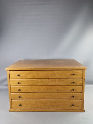 une petite commode en bois sur fond blanc