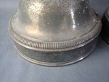 a silver bell sitting on top of a table next to a pair of shoes