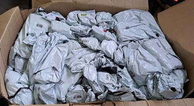 a cardboard box full of clothes that is sitting on the ground