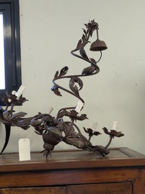 une sculpture métallique représentant un oiseau posée sur une commode