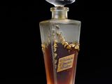 a close up of a bottle of perfume on a black surface