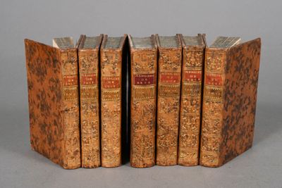 three old books are stacked on top of each other on a table