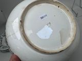 a person holding a white bowl that has a tag on it