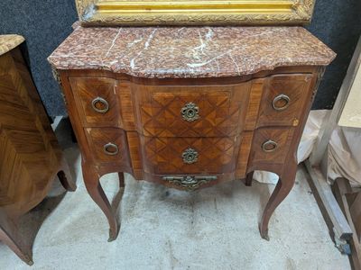 une commode au plateau en marbre, surmontée d'un miroir