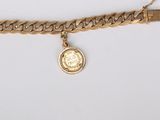 a close up of a gold chain bracelet with a coin on it