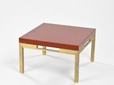 une image représentant une table basse rouge et dorée sur fond blanc