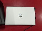 a white hp laptop sitting on top of a red table next to a printer