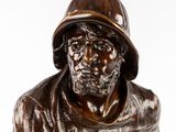 bronze statue of a man with a hat on his head