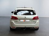 the rear end of a white car parked in a large room