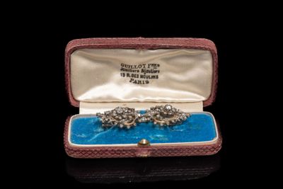 une photo d'une paire de boucles d'oreilles dans un écrin posé sur une table