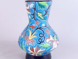 un vase bleu orné d'un motif floral