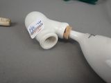 a white bottle with a cork stopper on a table