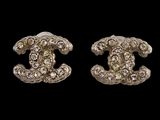 a pair of chanel earrings with diamonds on a black background