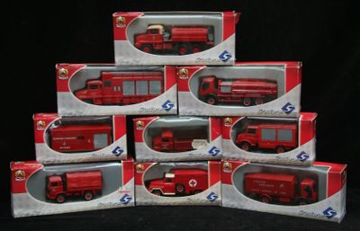 Plusieurs camions de pompiers rouges miniatures sont empilés les uns sur les autres