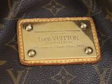 a louis vuitton bag with a gold plate on it