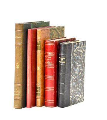several old books are lined up in a row on a white surface