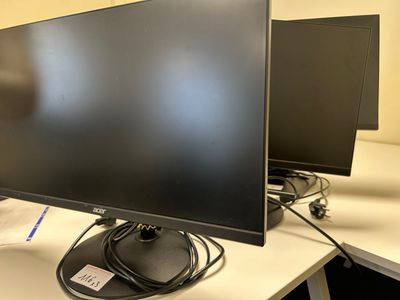 two monitors sitting on a desk next to each other
