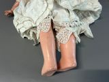 a doll that is sitting on the floor with a white dress