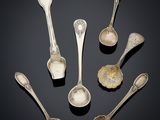 six silver spoons and two silver spoons on a black surface