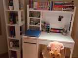 un ours en peluche assis sur une chaise devant un bureau