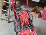 a red air compressor sitting on the floor in a garage