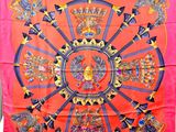 une image représentant un foulard en soie rouge orné d'un motif circulaire