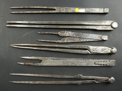 six pairs of old metal scissors sitting on top of a table
