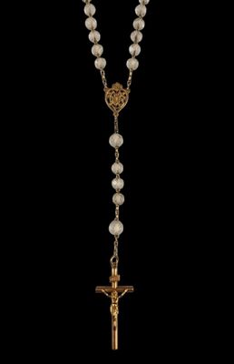 un chapelet orné d'une croix en or et de perles sur fond noir
