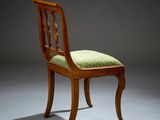 a wooden chair with a green cushion on top of it