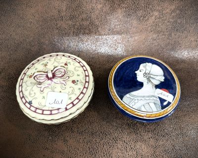 two small decorative boxes sitting on top of a brown surface