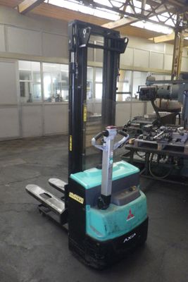 un chariot élévateur bleu dans un entrepôt, à côté d'autres machines