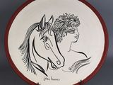 une assiette sur laquelle est représentée une femme et un cheval