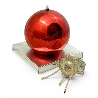 a red ornament sitting on top of a stack of books
