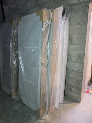 several pieces of furniture are wrapped in plastic in a room