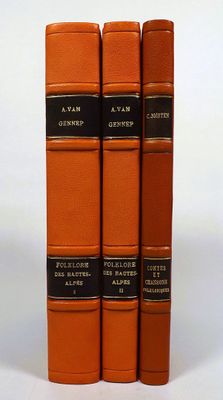 three orange books sitting on top of each other on a white surface