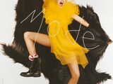 lady in a yellow dress and red shoes posing on a black bear