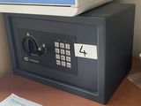 a small safe box on a desk with a cup of coffee