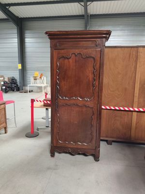 a tall wooden cabinet in the middle of a room